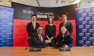 Sriram Muthukrishnan, DBS, signs the facility with Nathalie Louat, IFC (from left)