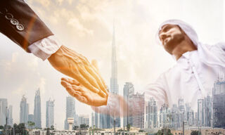 Dubai skyline with superimposed handshake between two businessmen (Image: Shutterstock)