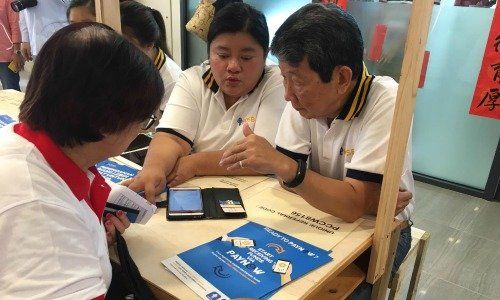 Digital Evangelist Syahida Rosli (middle) teaching an elderly customer how to use DBS’ digital banking channels